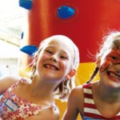 Glückliche Kinder auf der Hüpfburg Kletterleuchtturm von Crypton Event